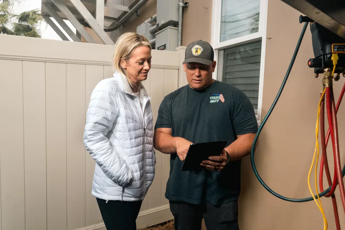 Technician reviewing the service report with a New Orleans homeowner