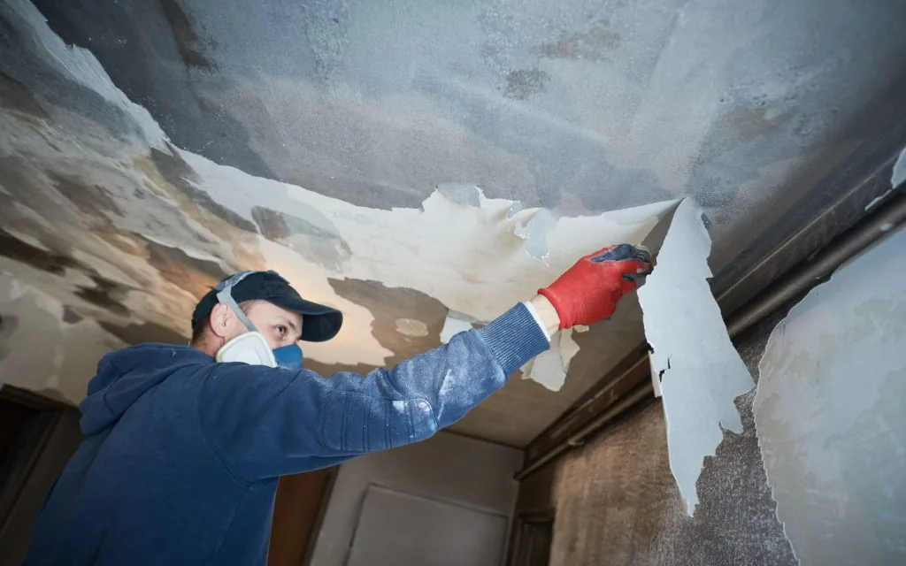 Worker removing fire-damaged materials during restoration in New Orleans